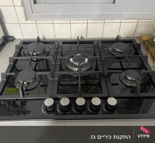 כיריים גז עם חמישה מבערים וכפתורי שליטה